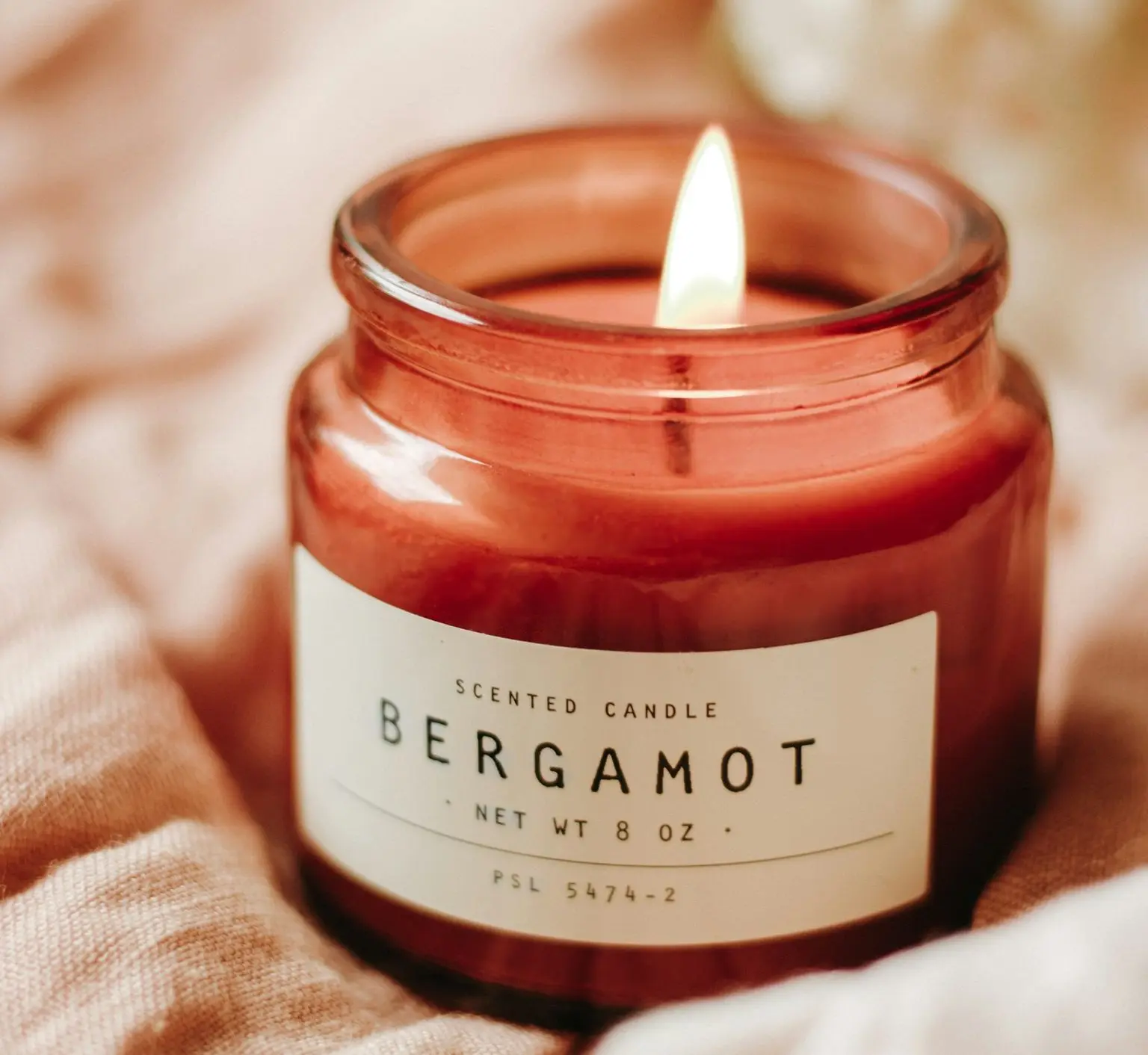 red candle on brown textile